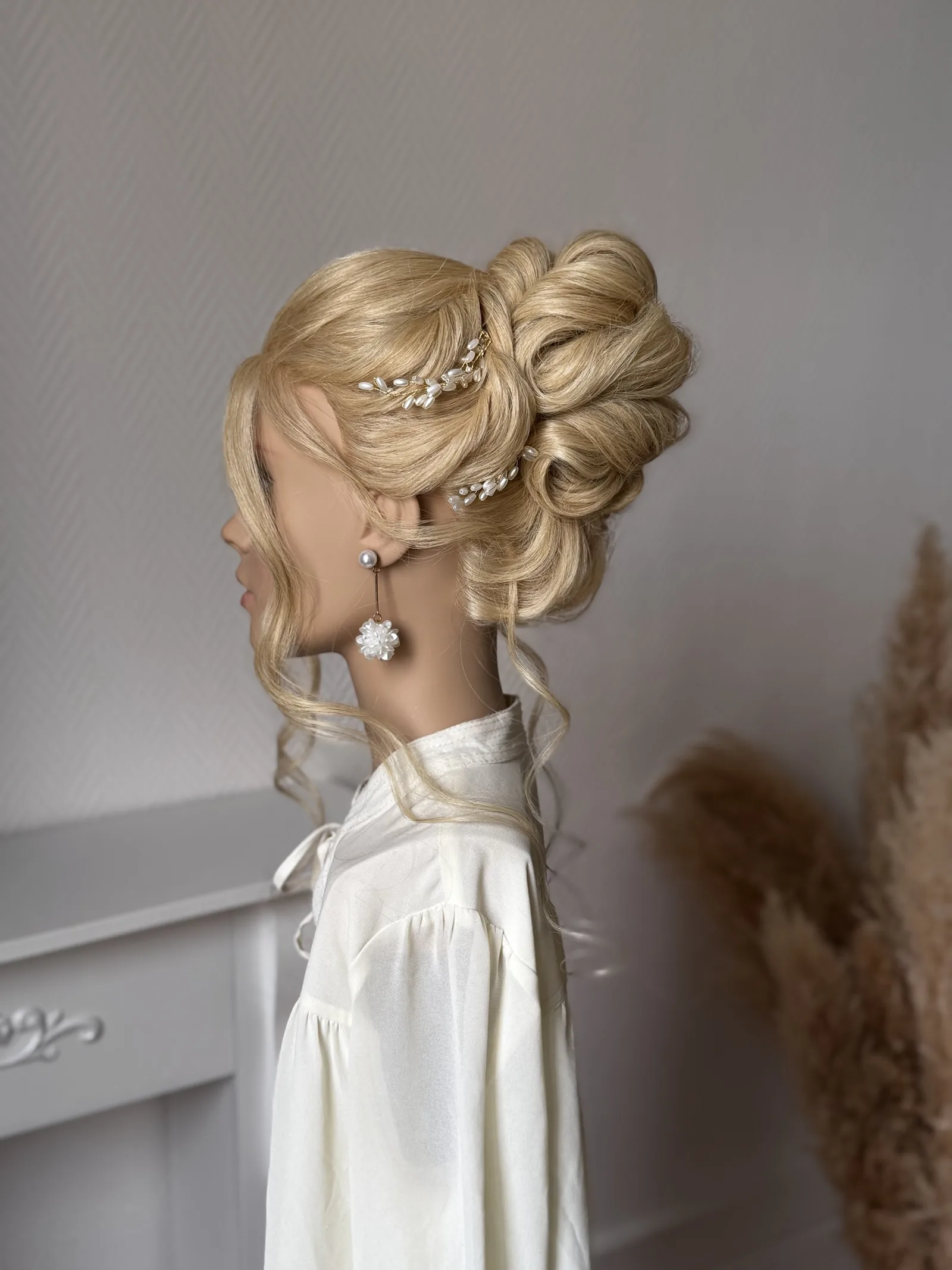 Chignon haut bouclé orné de perles, réalisé par Dina en formation Premiers Pas