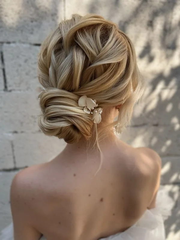 Chignon bas tressé blond orné de fleurs