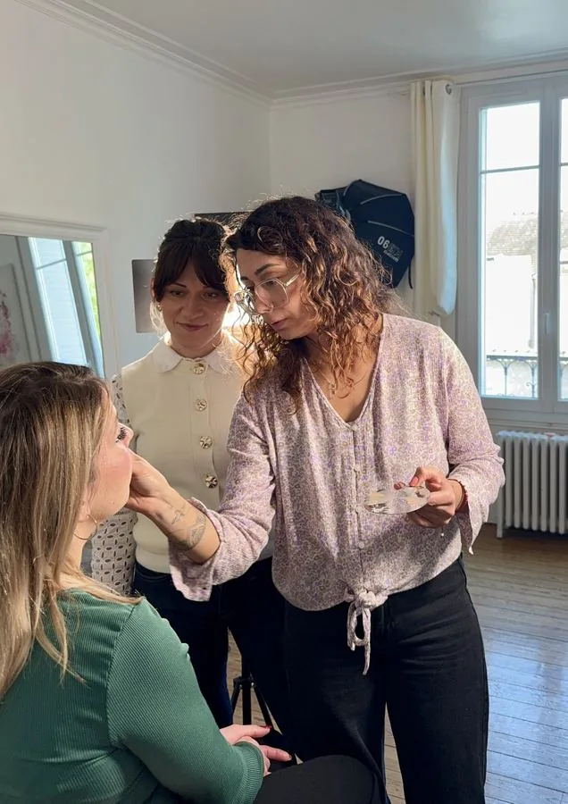 Une stagiaire maquille son modèle pendant la formation, Agata l'observe