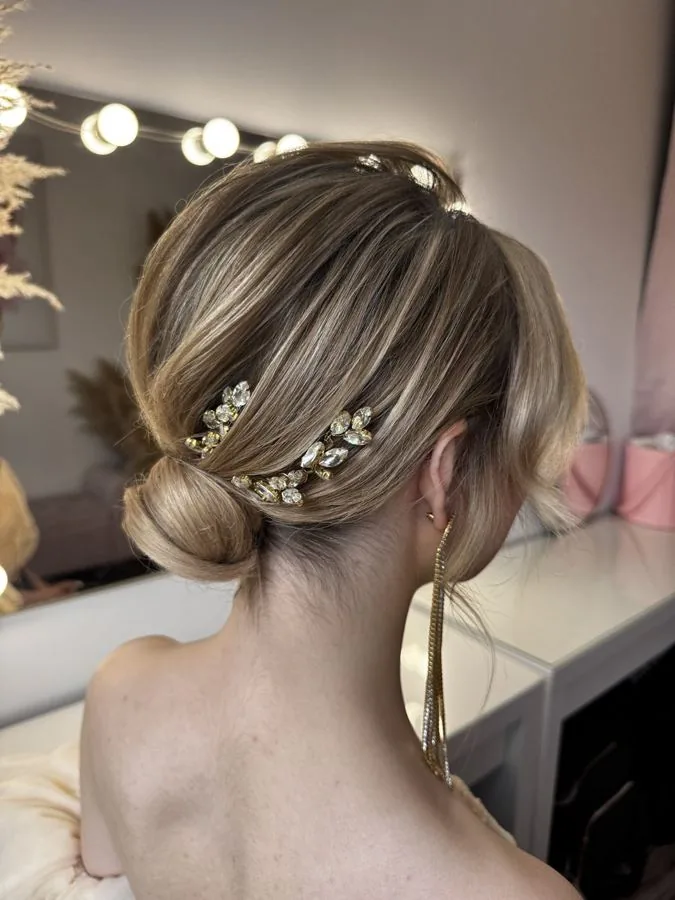 Chignon bas blond, orné de bijoux dorés