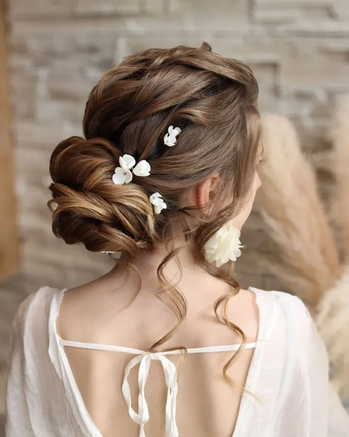 Chignon bas texturé avec petites fleurs blanches
