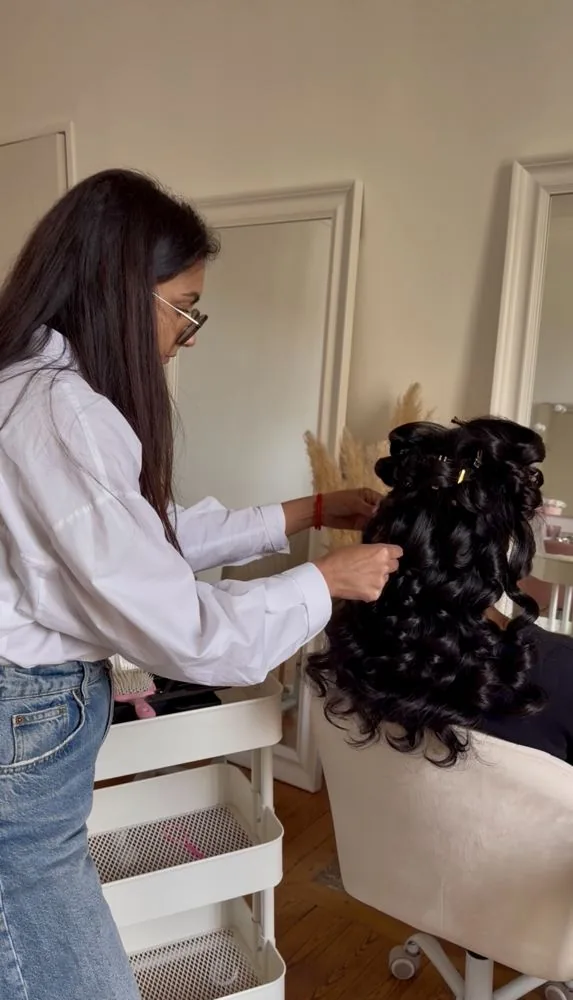Une stagiaire débutante réalise des boucles au studio pendant la formation coiffure de mariée